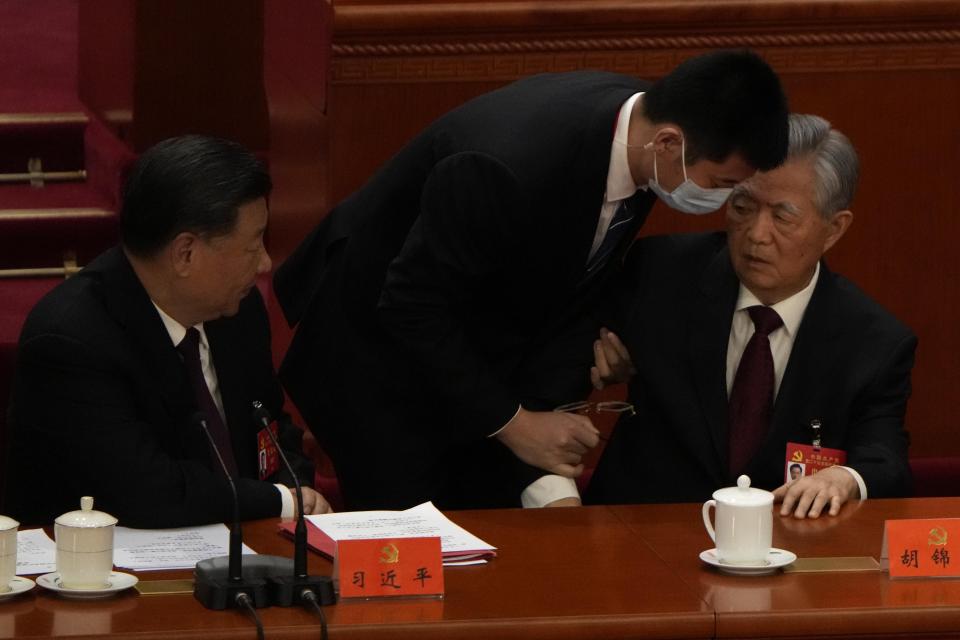 Chinese President Xi Jinping at left looks on as former Chinese President Hu Jintao is assisted to leave the hall during the closing ceremony of the 20th National Congress of China's ruling Communist Party at the Great Hall of the People in Beijing, Saturday, Oct. 22, 2022. Former Chinese President Hu Jintao, Xi's predecessor as party leader, was helped off the stage shortly after foreign media came in, sparking speculation about his health. (AP Photo/Ng Han Guan)