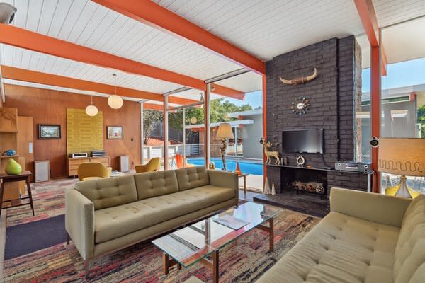 Walls of glass wrap around the main living area, framing striking views of the heated pool.