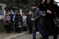 People attend a gathering to mark the first anniversary of the death of eight men killed by Russian forces in Bucha, Ukraine, Saturday, March 4, 2023. The eight had set up a roadblock on a road in the town in an attempt to prevent Russian troops from advancing, as they swept towards the Ukrainian capital at the start of their invasion. (AP Photo/Thibault Camus)
