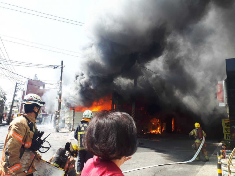 鐵皮屋起火後波及連棟住戶和商店，濃煙火勢悶燒，畫面驚人，消防員冒險搶救。（圖／讀者提供）