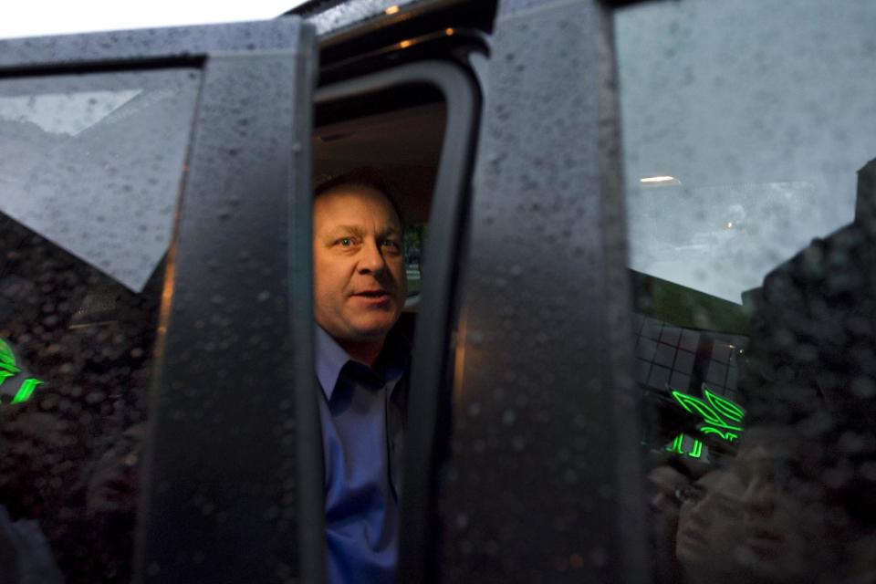 Former Boston Red Sox pitcher Curt Schilling, center, sits in the back seat of a vehicle as he departs the Rhode Island Economic Development Corporation headquarters in Providence, R.I., Monday, May 21, 2012. Schilling and Rhode Island's economic development agency met Monday to discuss the finances of his troubled video company. (AP Photo/Steven Senne)