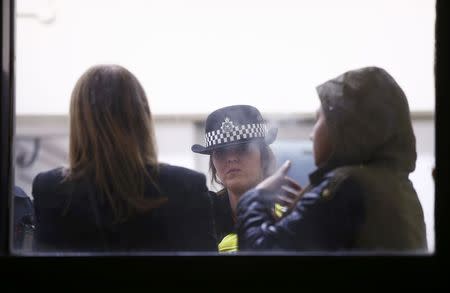 A police officer speaks to family members in the reception at Winson Green prison, run by security firm G4S, after a serious disturbance involving some 300 inmates broke out, in Birmingham, Britain, December 16, 2016. REUTERS/Peter Nicholls