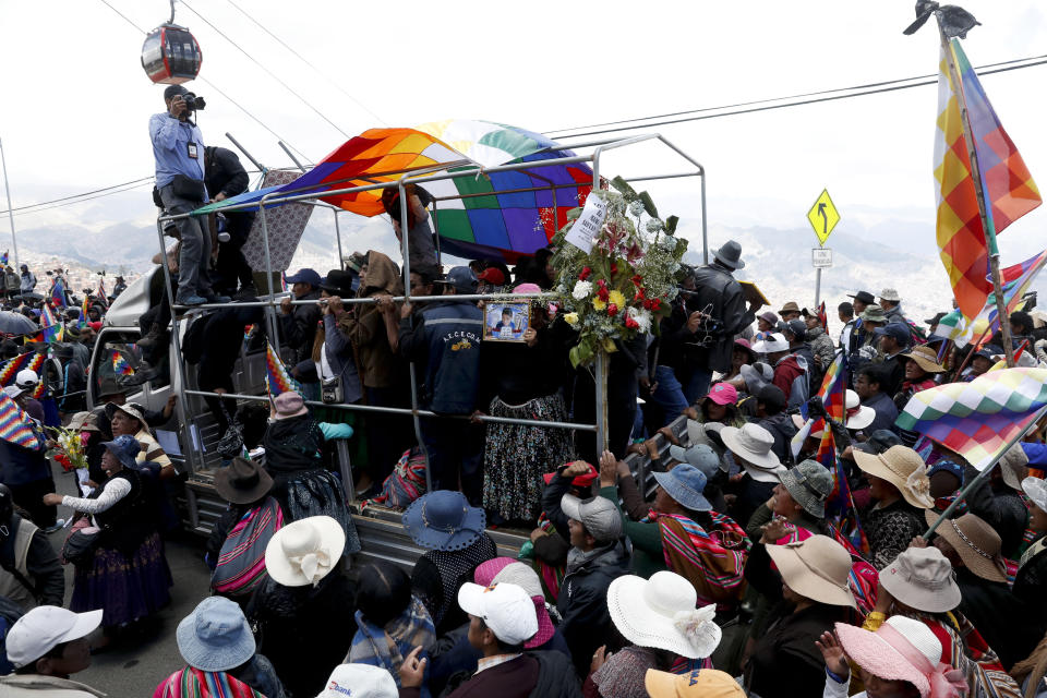 Anti-government demonstrators accompany the remains of people killed in clashes between supporters of former President Evo Morales and security forces, in a funeral procession into La Paz, Bolivia, Thursday, Nov. 21, 2019. At least eight people were killed Tuesday when security forces cleared a blockade of a fuel plant by supporters of former President Evo Morales at protesters in the city of El Alto. (AP Photo/Natacha Pisarenko)