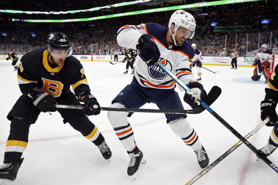 Edmonton Oilers' Riley Sheahan (23) defends against Boston Bruins' Brad Marchand (63) during the first period on an NHL hockey game in Boston, Saturday, Jan. 4, 2020. (AP Photo/Michael Dwyer)