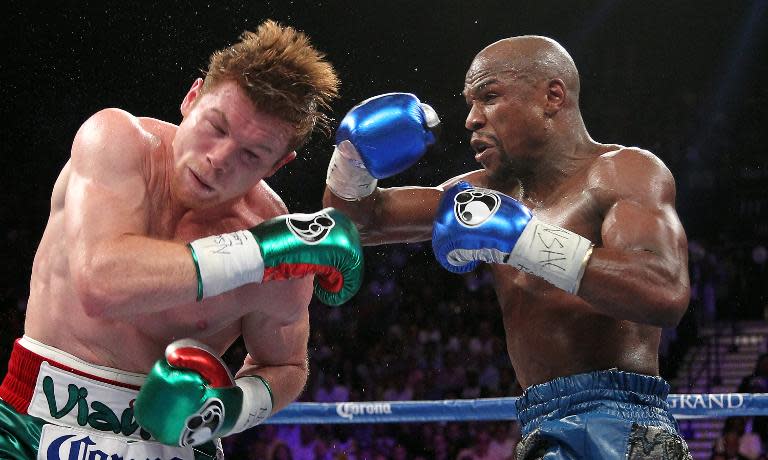 Floyd Mayweather throws a left at Canelo Alvarez during their WBC/WBA title fight on September 14, 2013, in Las Vegas