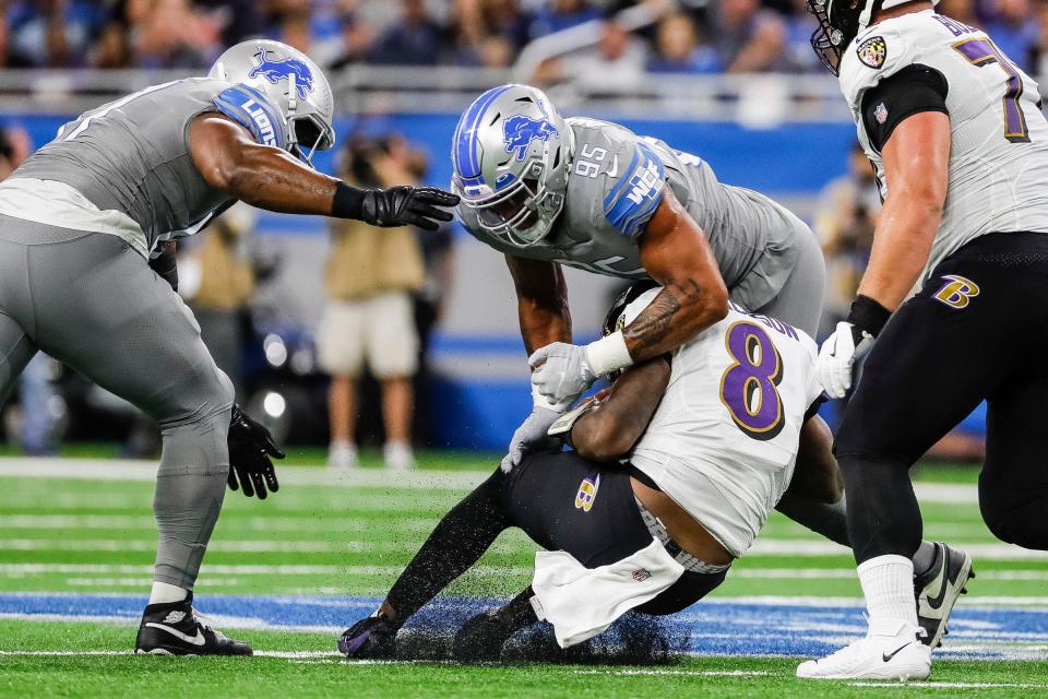 Detroit Lions linebacker Romeo Okwara (95) tackles Baltimore Ravens quarterback Lamar Jackson (8) during the first half at Ford Field in Detroit on Sunday, Sept. 26, 2021.