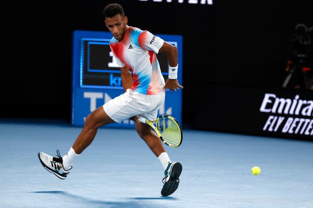 Felix Auger-Aliassime plays a shot between his legs