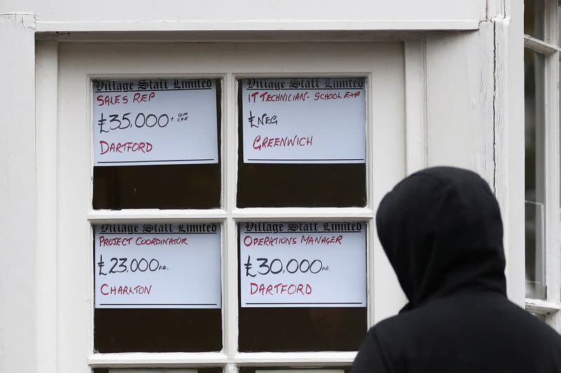 FILE PHOTO: A person looks at adverts in the window of a job agency in London