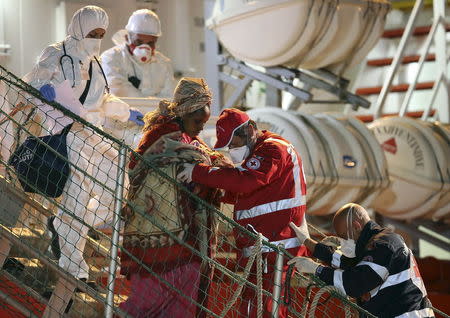 A woman is helped to disembark from tug boat Asso29 in the Sicilian harbour of Pozzallo, southern Italy, May 4, 2015. REUTERS/Antonio Parrinello