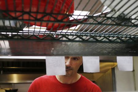 William Luz, who was recently released from the Barnstable County House of Corrections, cooks a diner's order at a restaurant in Sandwich, Massachusetts August 29, 2014. REUTERS/Brian Snyder