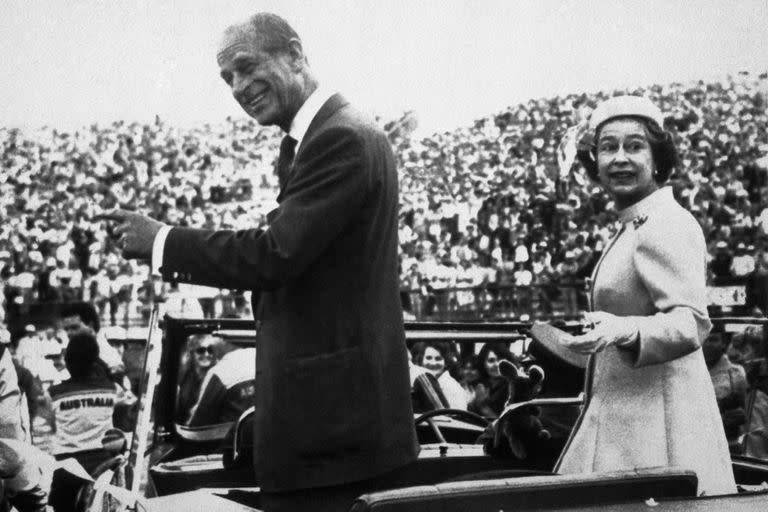 La reina Isabel y el príncipe Felipe de Gran Bretaña miran hacia atrás mientras conducen entre la multitud de atletas y oficiales durante la ceremonia de clausura de los XII Juegos de la Commonwealth, en el Centro Deportivo Queen Elizabeth II Jubilee, Brisbane, Australia, el 9 de octubre de 1982