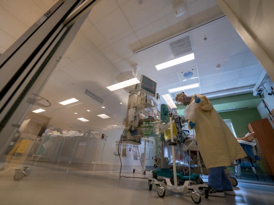 A nurse attends to a patient in the COVID-19 Intensive Care Unit at Surrey Memorial Hospital last June.  ( The Canadian Press/Jonathan Hayward - image credit)