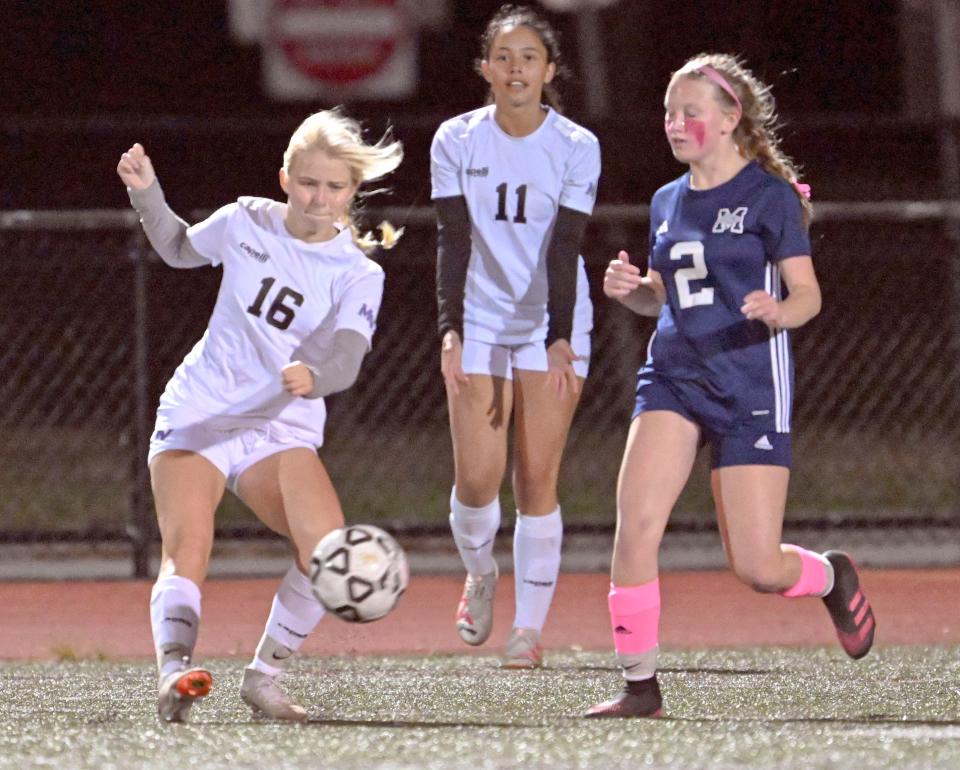 Emily Coogan of Martha's Vineyard kicks the ball past Lucy Bates of Monomoy girls soccer.