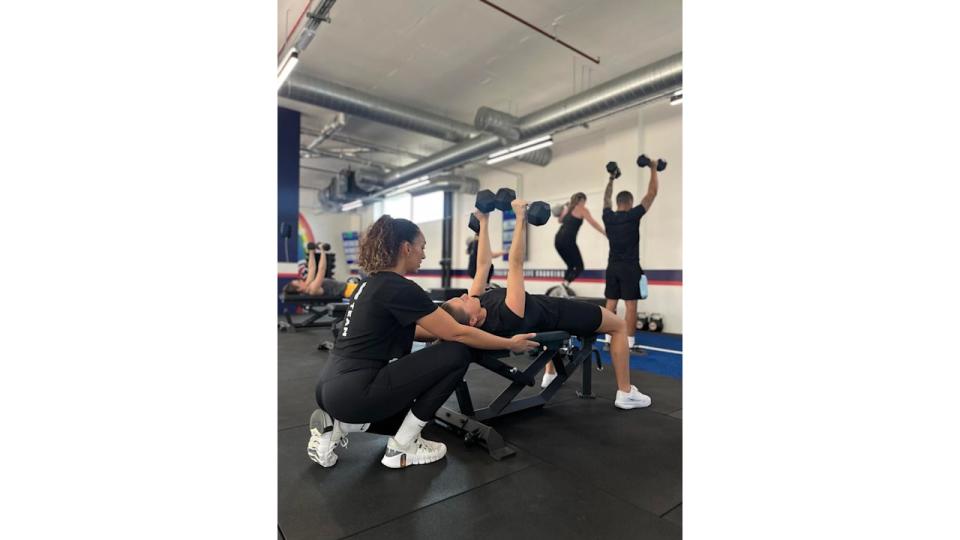 F45 personal trainer showing a client how to use dumbbells