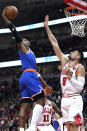 CORRECTS TO OG ANUNOBY, INSTEAD OF DAQUAN JEFFRIES New York Knicks forward OG Anunoby, left, goes up for a dunk against Chicago Bulls center Nikola Vucevic during the first half of an NBA basketball game in Chicago, Tuesday, April 9, 2024. (AP Photo/Nam Y. Huh)