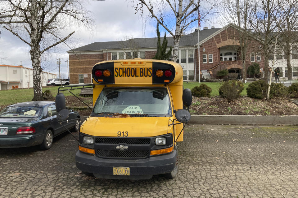 A school bus sits in front of the high school in Yamhill, Oregon, on Friday, Jan. 21, 2022. Many of the kids whom Nicholas Kristoff, 62, grew up with and who rode a bus with him to this high school have fallen onto bad times or have died. Kristoff, a former New York Times journalist, has written about this but wants to do more about the plight of those who are missing out on the American dream, and is running for governor of Oregon. But election officials decided he didn't meet the residence requirement, a decision he is appealing with the state Supreme Court. (AP Photo/Andrew Selsky)