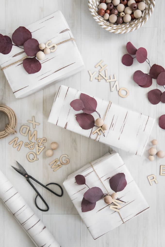 <p>For a natural look this holiday season, you can dress up your packages in wrapping paper that looks like birch bark, wood beads, and dried eucalyptus.<br></p><p><strong>Get the tutorial at <a href="https://ispydiy.com/diy-holiday-eucalyptus-wood-holiday-wrapping/" rel="nofollow noopener" target="_blank" data-ylk="slk:I SPY DIY;elm:context_link;itc:0;sec:content-canvas" class="link ">I SPY DIY</a>.</strong> </p>