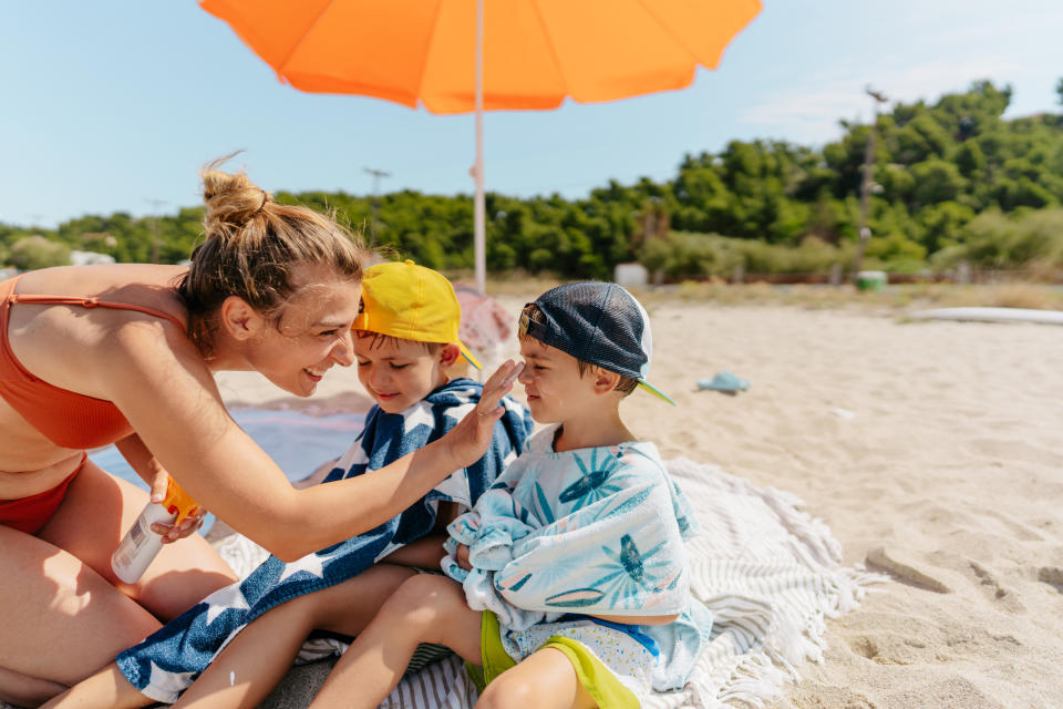 Photo of a happy family applying sunscreen while at the beach