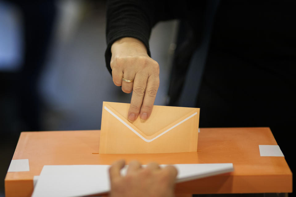 A woman casts her vote for the general election in Barcelona, Spain, Sunday, Nov.10, 2019. Spain holds its second national election this year after Socialist leader Pedro Sanchez failed to win support for his government in a fractured Parliament. (AP Photo/Emilio Morenatti)