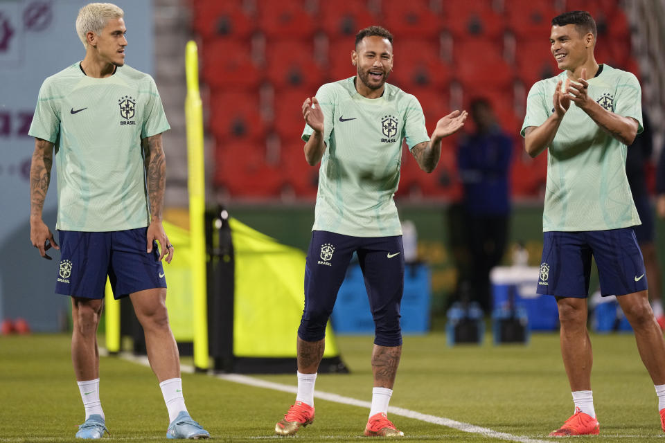 Brazil's Neymar, center, Pedro, left, and Thiago Silva exercise during a training session at the Grand Hamad stadium, in Doha, Qatar, Wednesday, Nov. 23, 2022. Brazil will play their first match in the World Cup against Serbia on Nov. 24. (AP Photo/Andre Penner)