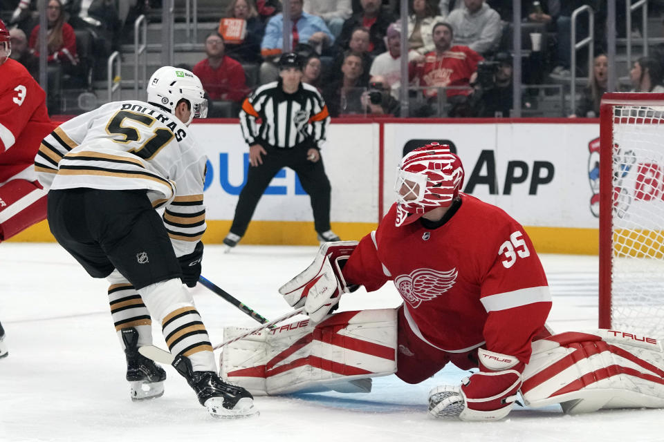 Boston Bruins center Matthew Poitras (51) scores on Detroit Red Wings goaltender Ville Husso (35) during the first period of an NHL hockey game Saturday, Nov. 4, 2023, in Detroit. (AP Photo/Carlos Osorio)