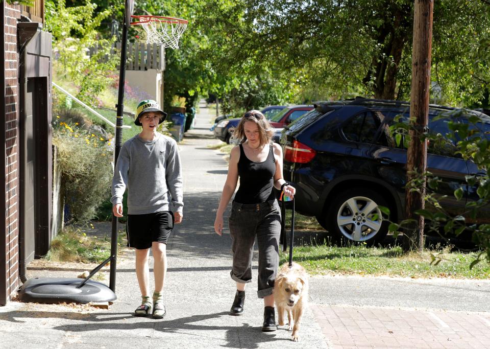 Jennifer Haller, the first person to receive a trial dose of a COVID-19 vaccine, and her son Hayden, 16, walk their dog on Sunday, July 19, 2020.