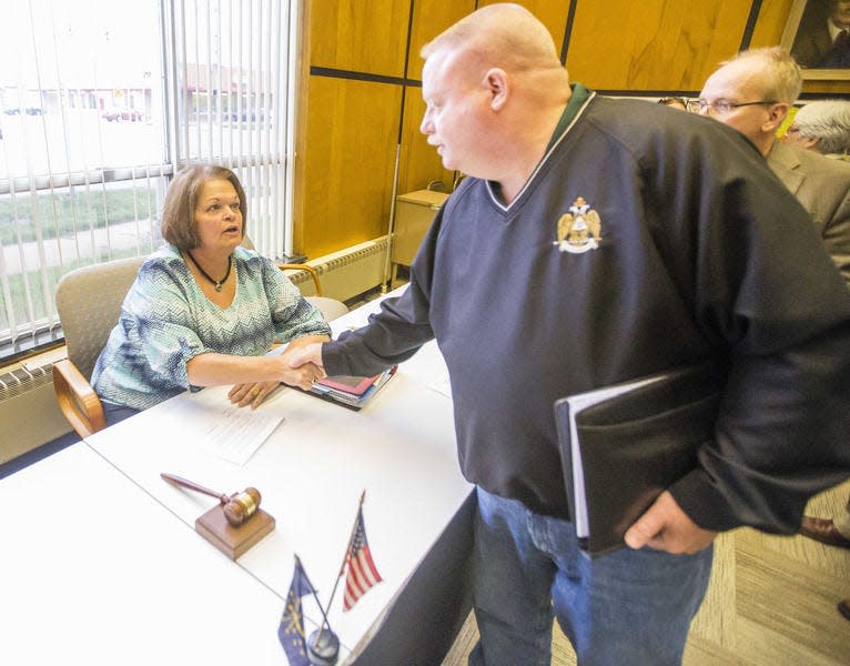 Penn Township board President Kent Hizer shakes Osceola Town Council President Debra Davis’ hand after a meeting.