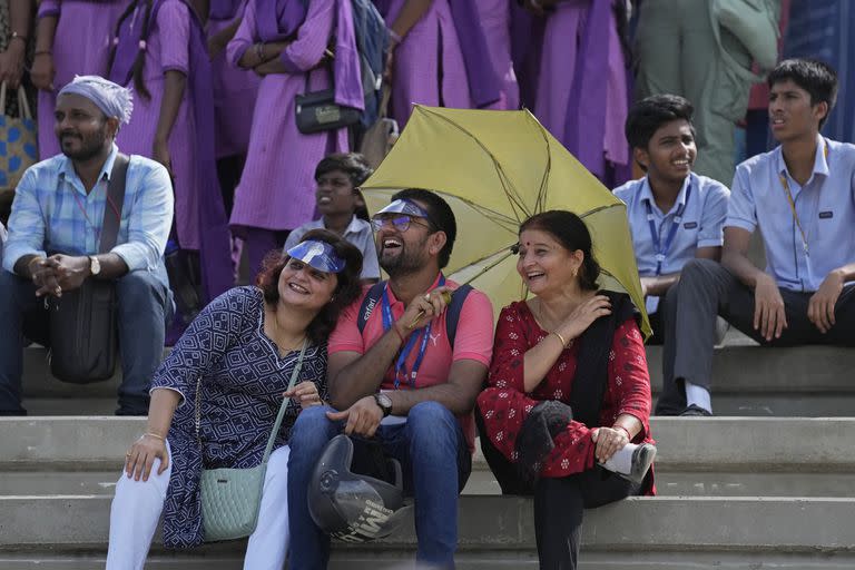 La gente escucha una transmisión en vivo de científicos hablando después del lanzamiento de la nave espacial Chandrayaan-3, la palabra para 