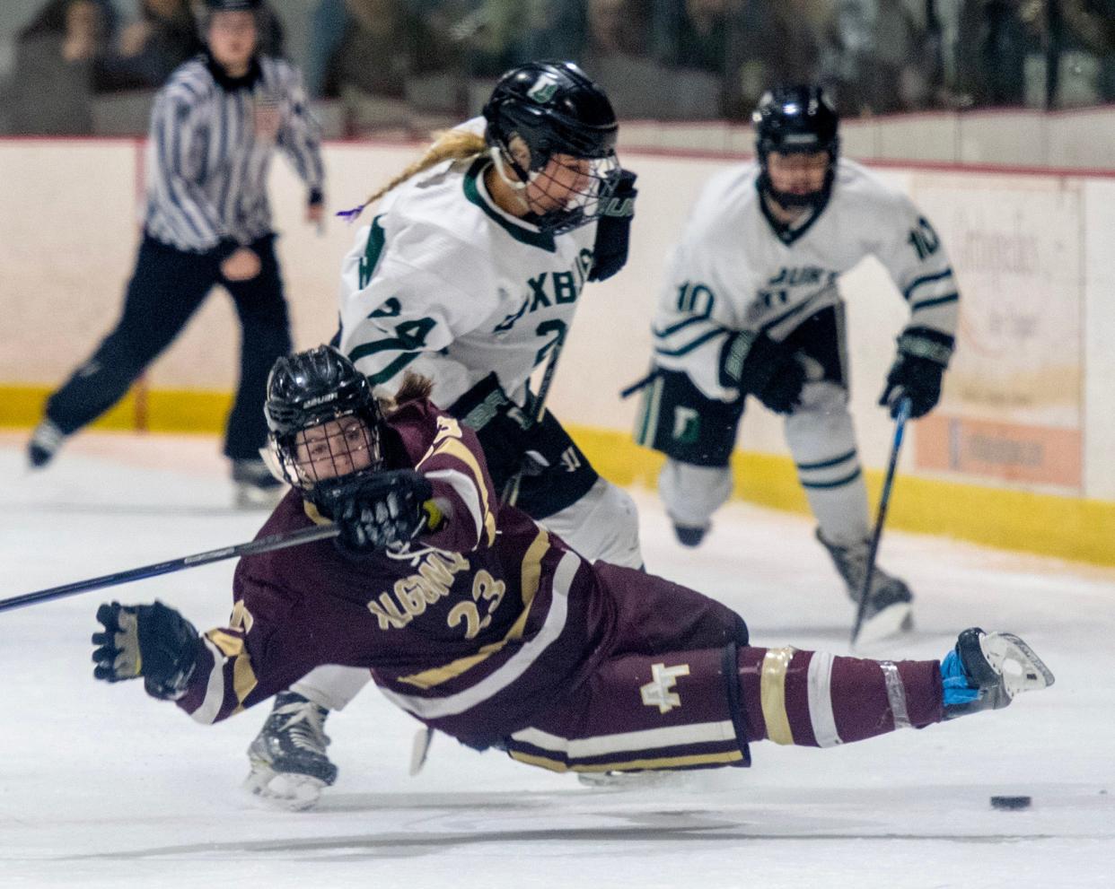 Algonquin’s Emily Johns is brought down by Duxbury’s Lucia Rose in a hockey game on March 9, 2024.