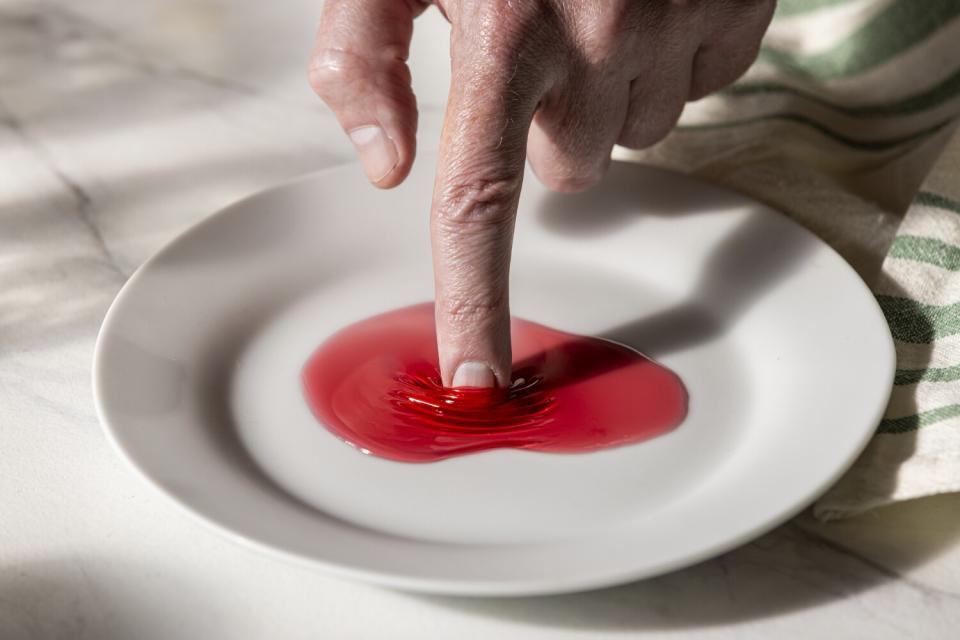 Checking the thickness and texture of while making blackberry jelly.