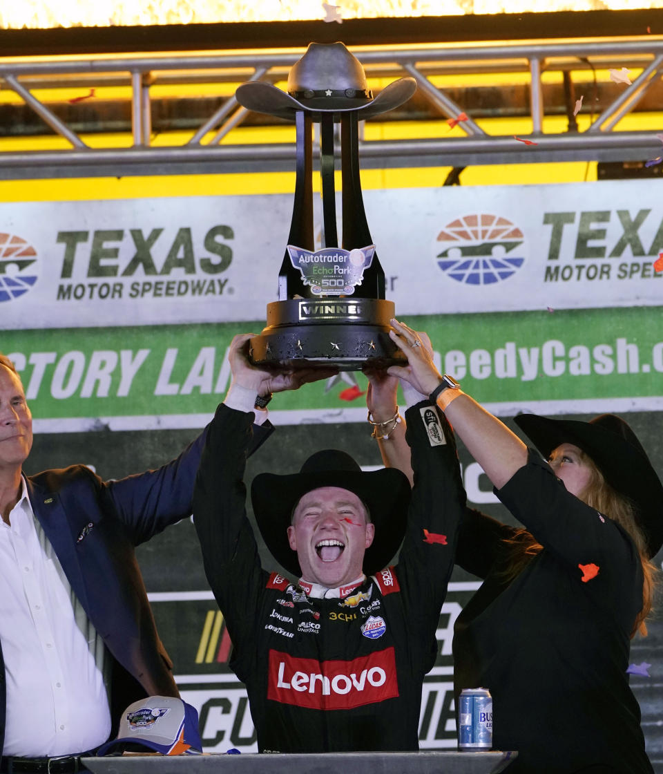 Tyler Reddick lifts the winners trophy in victory lane after winning the the NASCAR Cup Series auto race at Texas Motor Speedway in Fort Worth, Texas, Sunday, Sept. 25, 2022. (AP Photo/Larry Papke)