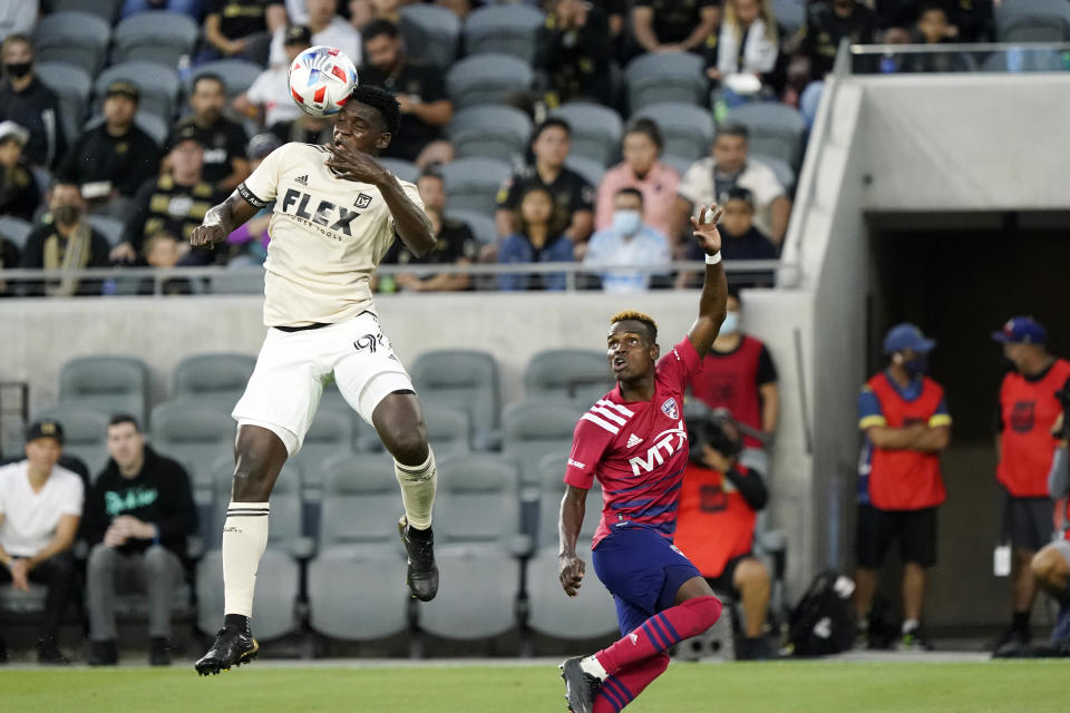 Los Angeles FC defender Jesus Murillo, left, heads the ball over Dallas FC forward Jader Obrian during the first half of an MLS soccer match Wednesday, June 23, 2021, in Los Angeles. (AP Photo/Marcio Jose Sanchez)