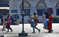 People from other states trying to get back to their homes arrive to board trains at the Chhatrapati Shivaji Maharaj Terminus in Mumbai, India, Tuesday, May 19, 2020. The number of coronavirus cases in India has surged past 100,000, and infections are now on the rise in the home states of the migrant workers who left cities and towns during the nationwide lockdown. (AP Photo/Rajanish Kakade)