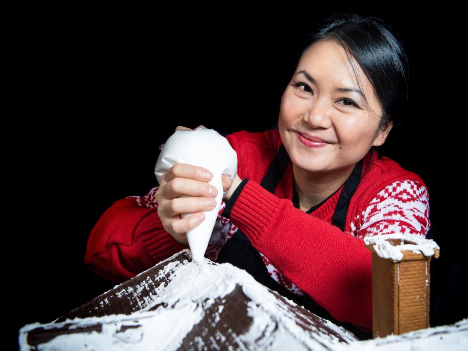 Cake designer Michelle Wibowo works on her gingerbread version of the McCallister house