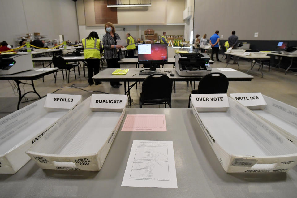 Cobb County Election officials prepare for a recount, Tuesday, Nov. 24, 2020, in Marietta, Ga. County election workers across Georgia have begun an official machine recount of the roughly 5 million votes cast in the presidential race in the state. The recount was requested by President Donald Trump after certified results showed him losing the state to Democrat Joe Biden by 12,670 votes, or 0.25% (AP Photo/Mike Stewart)