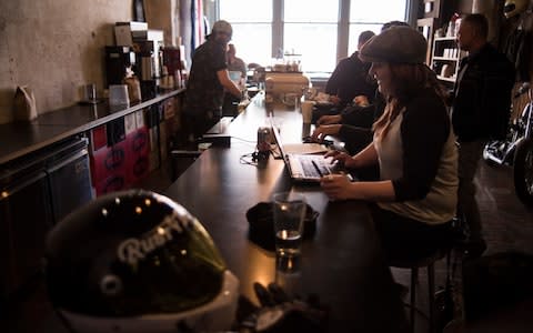 People chat and work in Blip Roasters in Kansas City, Missouri - Credit: Neville Elder for The Telegraph