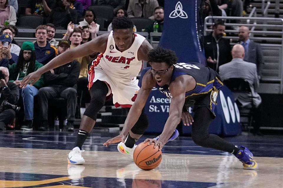 Miami Heat's Victor Oladipo (4) and Indiana Pacers' Jalen Smith (25) battle for the ball during the second half of an NBA basketball game, Monday, Dec. 12, 2022, in Indianapolis. (AP Photo/Darron Cummings)