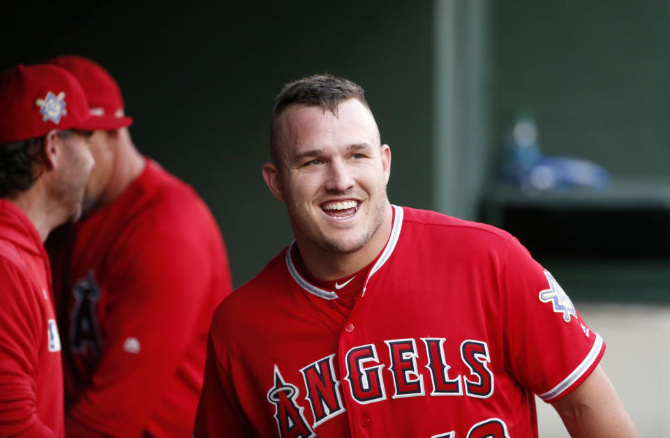 Los Angeles Angels designated hitter Mike Trout smiles in the dugout after he scored on a home run by Brian Goodwin against the Texas Rangers during the first inning of a baseball game Monday, April 15, 2019, in Arlington, Texas. (AP Photo/Michael Ainsworth)