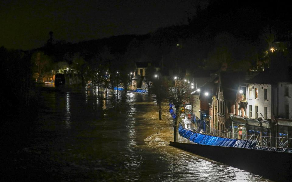 Temporary flood barriers hold back the river Severn in Ironbridge, Shropshire - PA