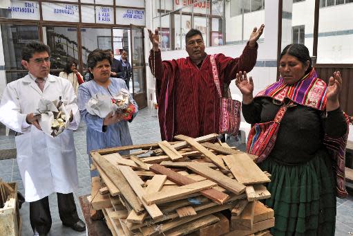 El director del Hospital Agromont, Jaime Agramont, (d) y curanderos indígenas realizan un ritual para llamar al "Ajayu" (espíritu) de un paciente, el 5 de diciembre de 2013 en El Alto, Bolivia (AFP | Aizar Raldes)