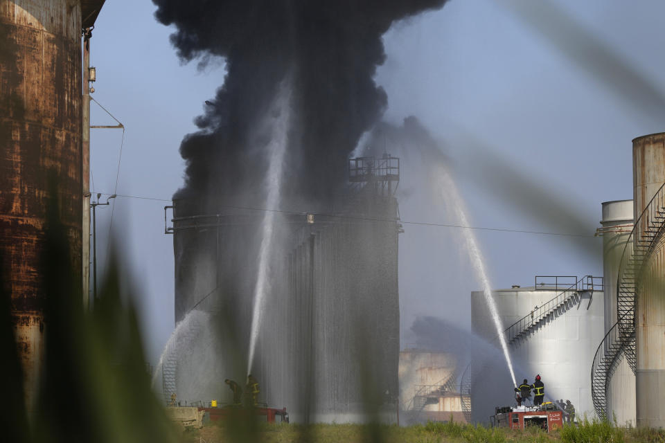 Firefighters work to extinguish a fire in an oil facility in the southern town of Zahrani, south of the port city of Sidon, Lebanon, Monday, Oct. 11, 2021. A huge fire broke out at an oil facility in southern Lebanon's coastal town of Zahrani, but the cause was not immediately known. (AP Photo/Hassan Ammar)