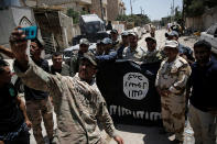 <p>Members of the Iraqi Army’s 9th Armoured Division are photographed with an Islamic State flag, claimed after fighting with Islamic State militants in western Mosul, Iraq, June 17, 2017. (Photo: Alkis Konstantinidis/Reuters) </p>