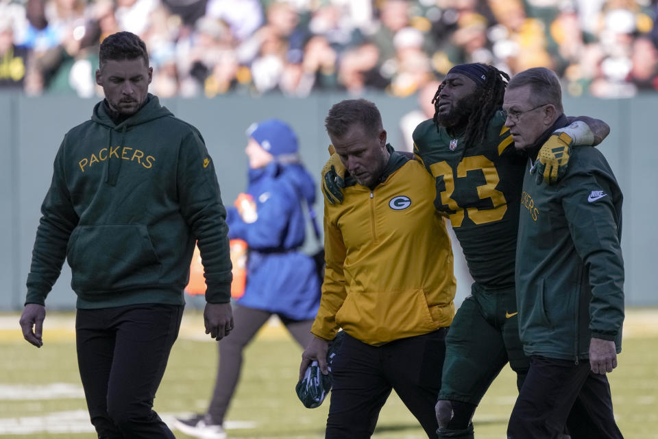 Green Bay Packers running back Aaron Jones (33) is walked off the field by trainers during the first half of an NFL football game against the Los Angeles Chargers, Sunday, Nov. 19, 2023, in Green Bay, Wis. (AP Photo/Morry Gash)