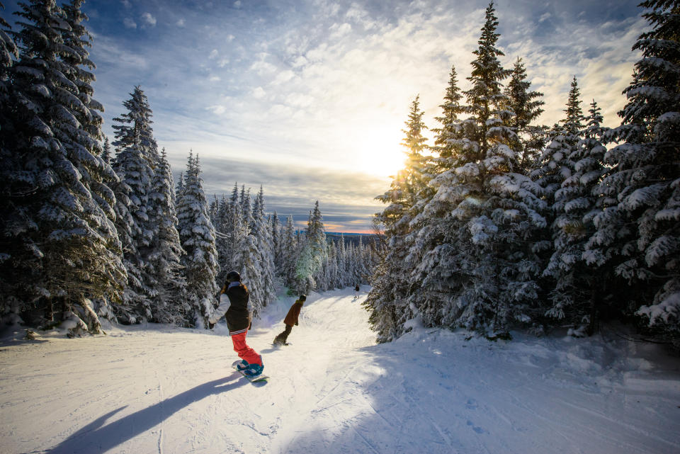 Snowboarders going down a trail at Le Valinouet in Quebec