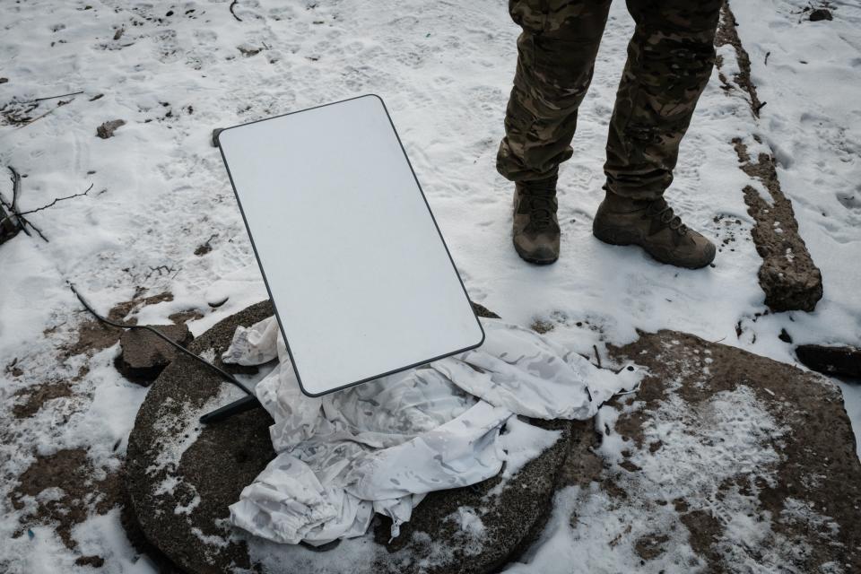 A Ukrainian serviceman stands next to the antenna of the Starlink satellite-based broadband system in Bakhmut on February 9, 2023, amid the Russian invasion of Ukraine. (Photo by YASUYOSHI CHIBA / AFP) (Photo by YASUYOSHI CHIBA/AFP via Getty Images)