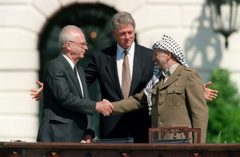 Bill Clinton watches on as Yasser Arafat and Yitzhak Rabin shake hands outside the White House in 1993