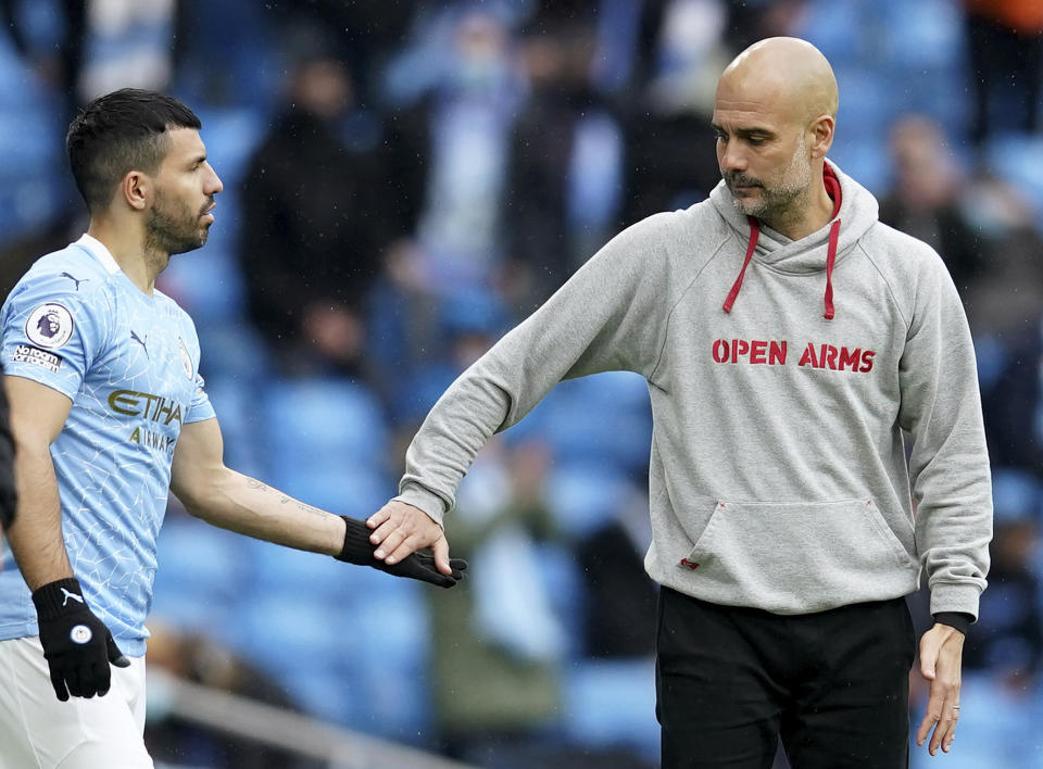 Sergio Agüero del Manchester City recibe el saludo del técnico Pep Guardiola al ingresar en el partido contra Everton por la Liga Premier inglesa, el domingo 23 de mayo de 2021. (AP Foto/Dave Thompson, Pool)