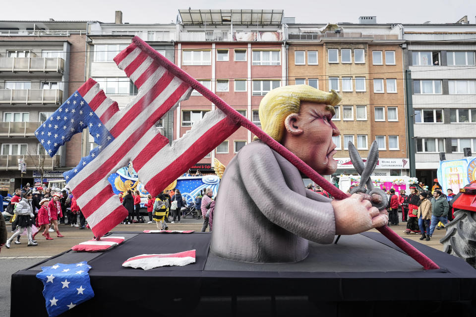 A carnival float depicting Donald Trump with a USA flag cut in the shape of a Nazi swastika in a backstreet for the start of the traditional carnival parade in Duesseldorf, Germany, on Monday, Feb. 12, 2024. The foolish street spectacles in the carnival centers of Duesseldorf, Mainz and Cologne, watched by hundreds of thousands of people, are the highlights in Germany's carnival season on Rosemonday. (AP Photo/Martin Meissner)