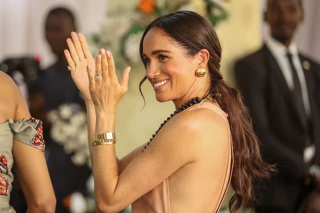 <p>KOLA SULAIMON/AFP via Getty</p> Britain's Meghan, Duchess of Sussex, gestures as she arrives with Britain's Prince Harry (unseen), Duke of Sussex, during their visit at the Lightway Academy in Abuja on May 10, 2024 as they visit Nigeria as part of celebrations of Invictus Games anniversary.