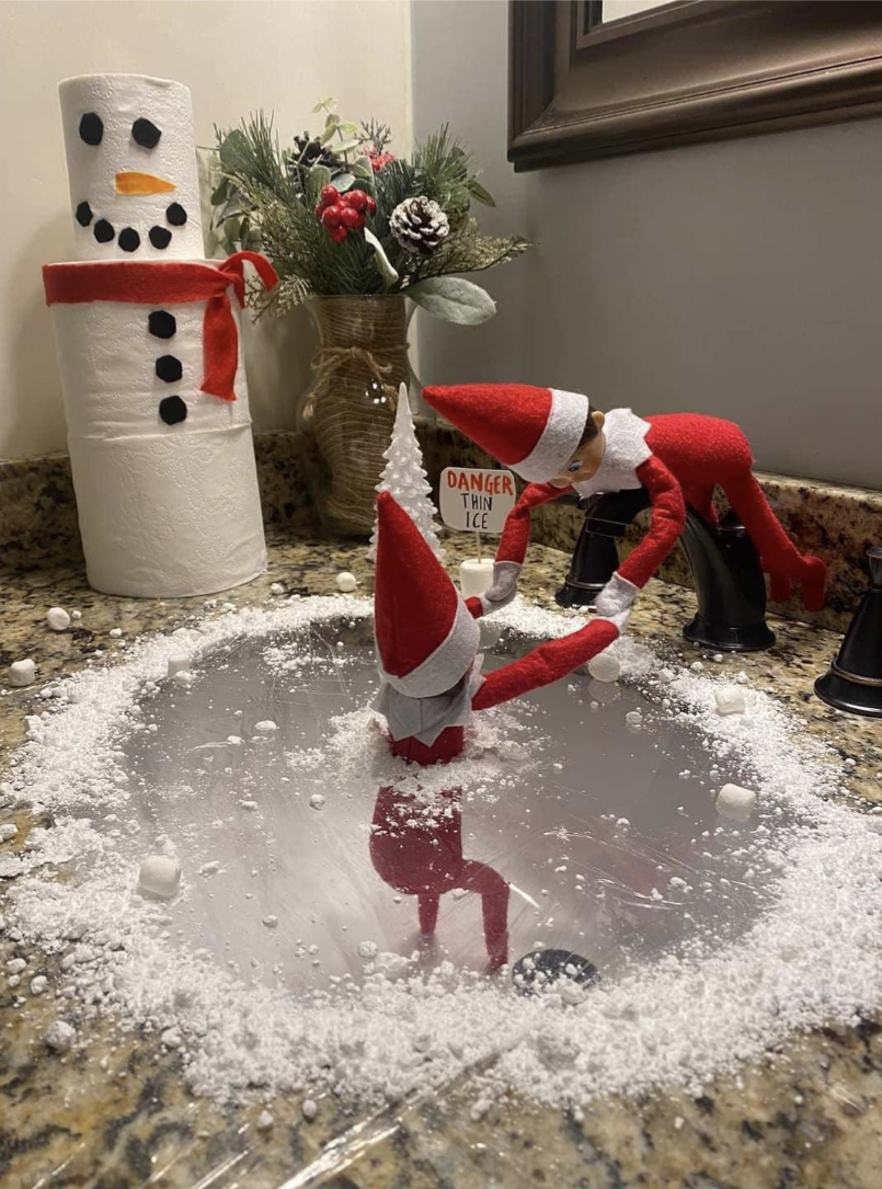 One Elf on the Shelf pulling another from some fake ice